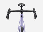 Front view of an endurance road bicycle with a light lavender-purple frame, black drop handlebars, black saddle, and black grips, shown against a solid light gray background.