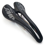 Product image of the Selle SMP Nymber Saddle in black leather with stitched SMP logo and central ergonomic cutout, diagonal view, where yuou can also see the product name 'nymber' in thast same stitching.