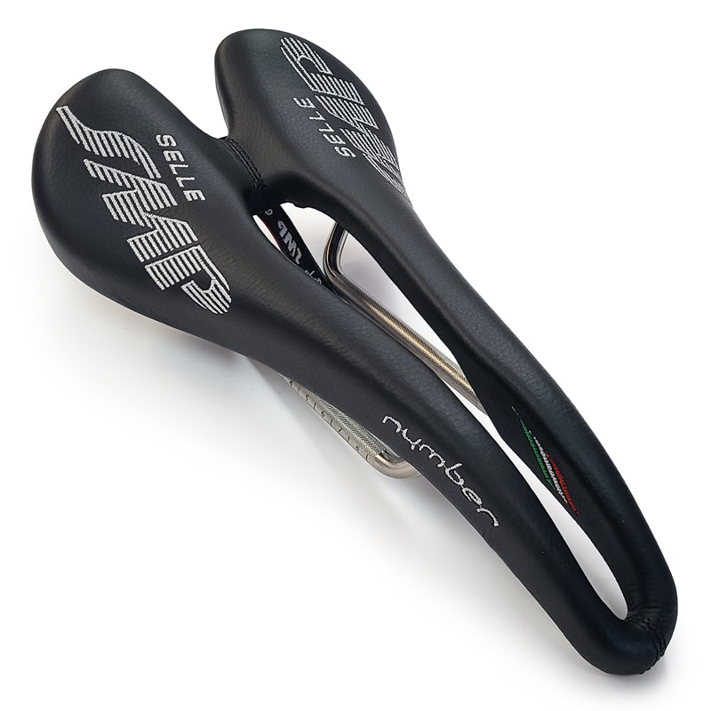 Product image of the Selle SMP Nymber Saddle in black leather with stitched SMP logo and central ergonomic cutout, diagonal view, where yuou can also see the product name 'nymber' in thast same stitching.