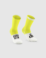 Yellow and white socks with visible branding on a light gray background