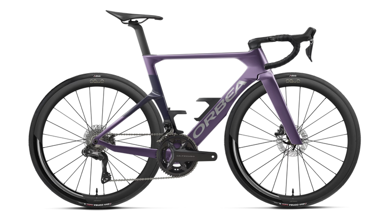 A purple and violet Orbea performance road bicycle with carbon fiber wheels, drop handlebars, and a carbon fiber fork, shown from a side profile on a white background.