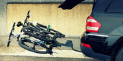BuzzRack Scorpion H E‑Bike Hitch Rack mounted on a vehicle, carrying two bikes outdoors.