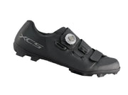 A black SCX2 cycling shoe with a dial closure system and a silver XCS logo on the heel, shown against a plain white background.