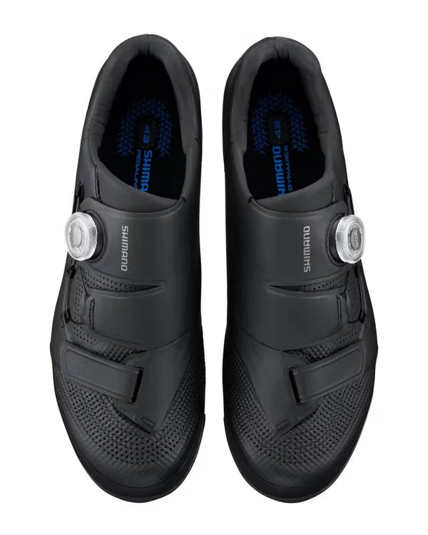 A pair of Shimano road cycling shoes in black, shown from a top-down view against a white background. Each shoe features a dial system with silver metal dials and the Shimano brand name printed on the side.