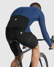 Person wearing a blue and black cycling outfit on a white background