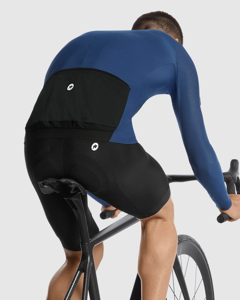 Person wearing a blue and black cycling outfit on a white background