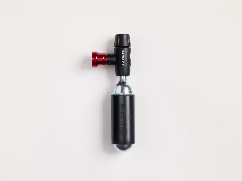 A Trek bicycle CO₂ inflater with a black body, red anodized valve, and silver metallic core, shown on a clean white background.