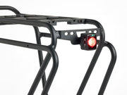 Close-up of the rear section of the Trek BackRack Deluxe MIK Studs Rear Rack with a mounted rear bicycle light attached to the integrated accessory mount.