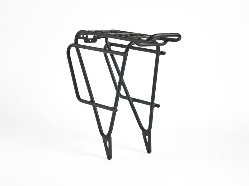 Trek BackRack Deluxe MIK Studs Rear Rack shown from a three-quarter right-side angle, featuring the aluminum cargo platform, side support rails, and integrated mounting structure.