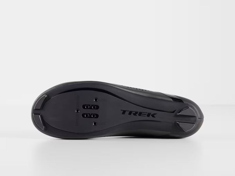 Bottom profile view of black Trek Circuit Wide shoe showing nylon composite sole with molded Trek logo, traction treads, and universal 3-bolt road and 2-bolt SPD cleat mounting zone