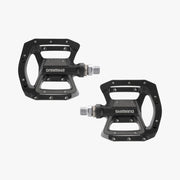 Two black Shimano bicycle pedals on a white background