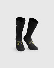 Black socks with yellow text and white Assos logo, on a light gray background