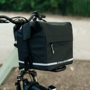 Urban Arrow Breeze Front Carrier Pannier MIK mounted on the front carrier of an Urban Arrow Breeze, lifestyle view with greenery in the background