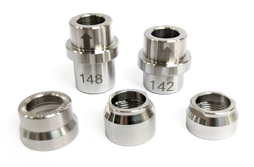 Wahoo KICKR trainer adapter kit showing five silver axle adapters and lock nuts, including 12x142 and 12x148 spacers, on a white background