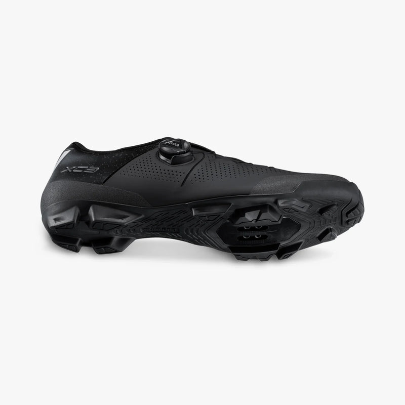 Shimano SH-XC302 cycling shoe in black, tilted to show the side and tread