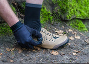 Cyclist adjusting a Shimano SH-XC302 shoe on a forest trail