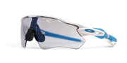 Oakley sport sunglasses with a silver and white frame, blue accents on the temples, and a dark gray shield lens, shown on a white background.