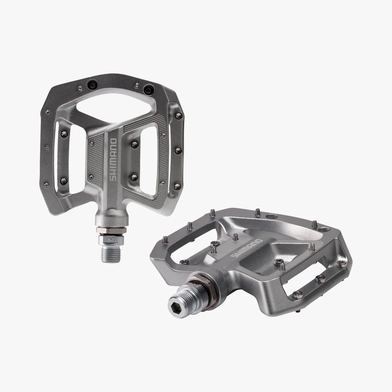 Two Shimano bicycle pedals on a white background