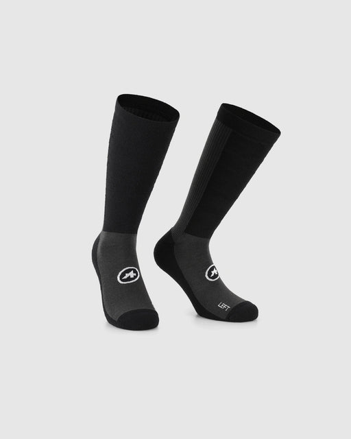 A pair of black and dark gray athletic crew socks with white logo graphics, displayed on a light gray background.