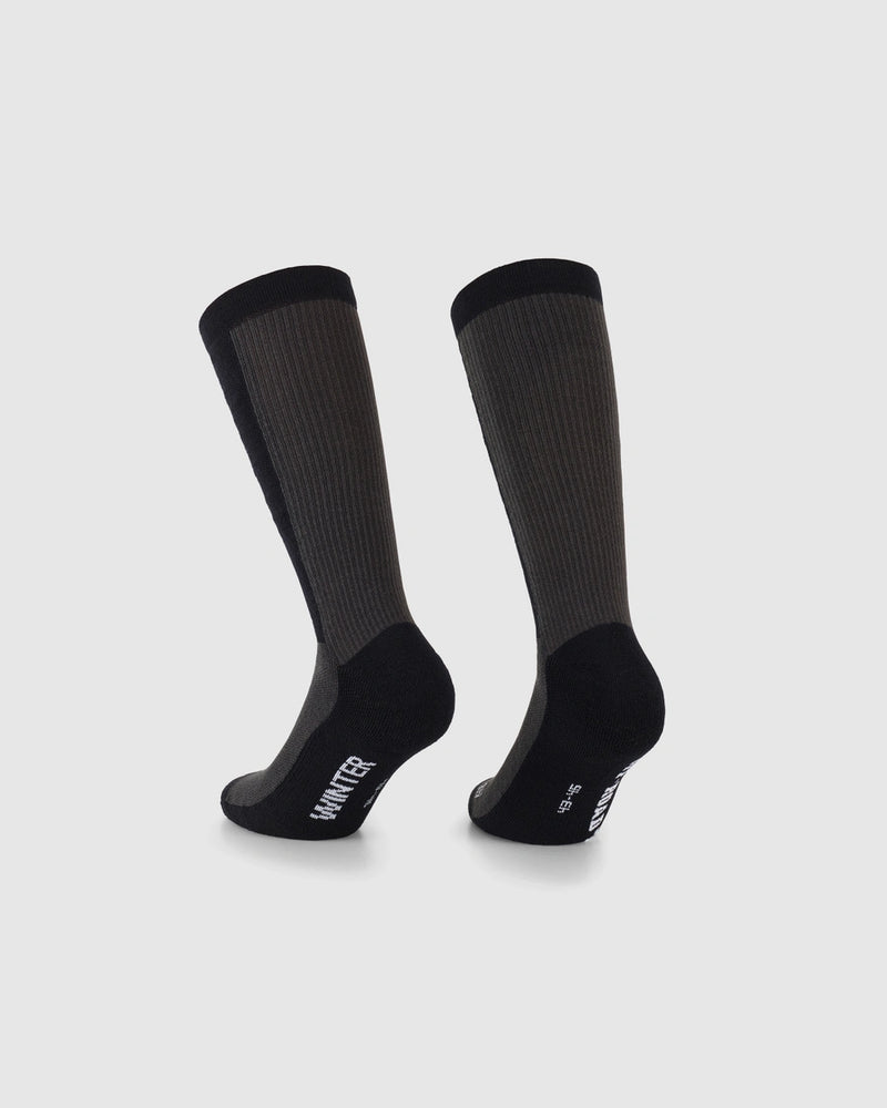 A pair of dark gray and black crew socks shown from the back on a light gray background, with the brand name 'WINTER' printed in white on the heel.